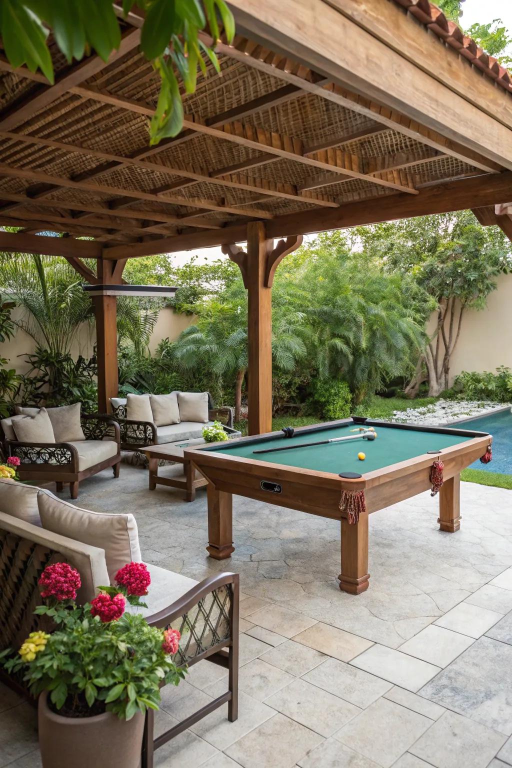 A cozy pool table setup under a wooden pergola with seating and garden plants.