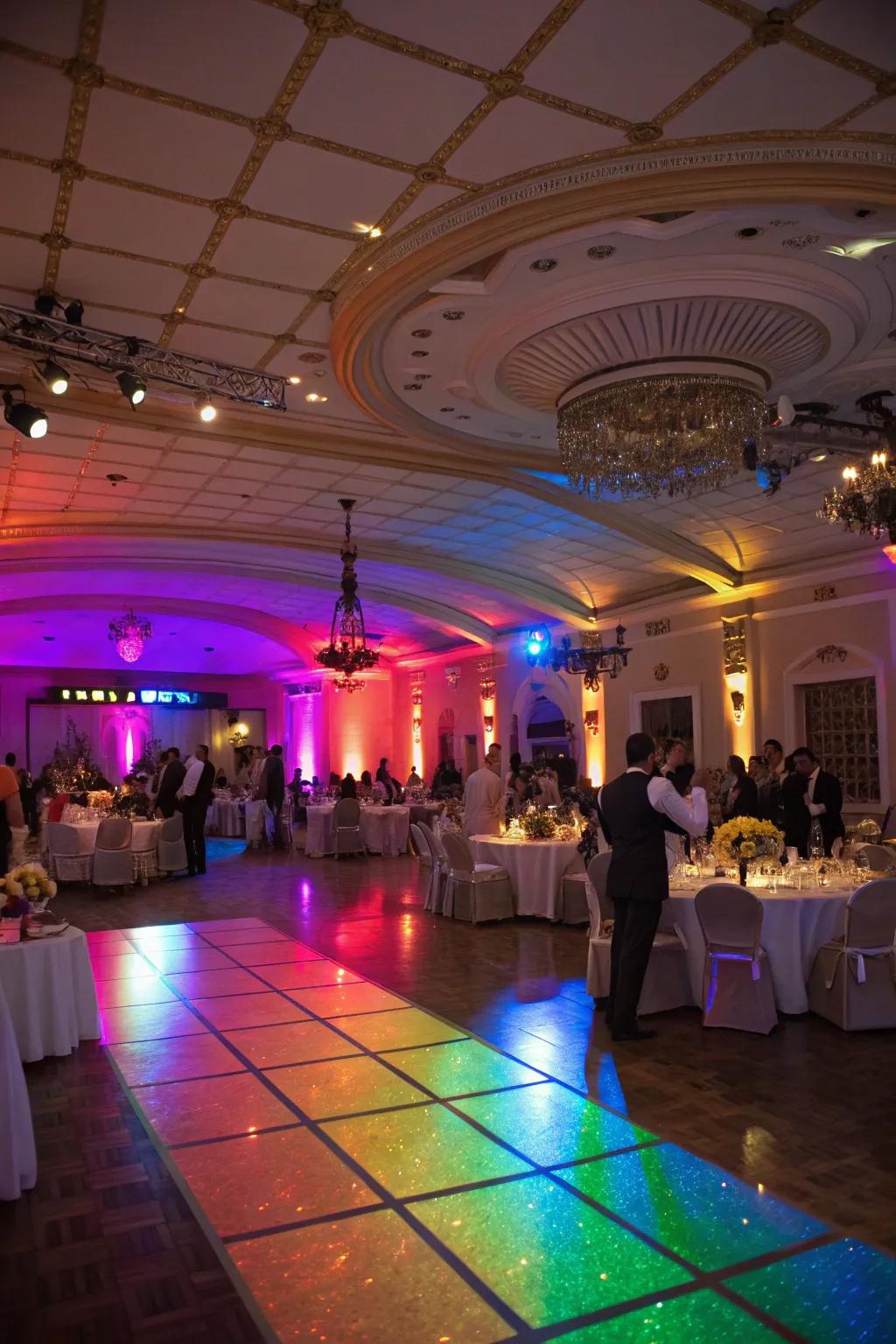 A wedding reception venue beautifully lit with rainbow lighting.