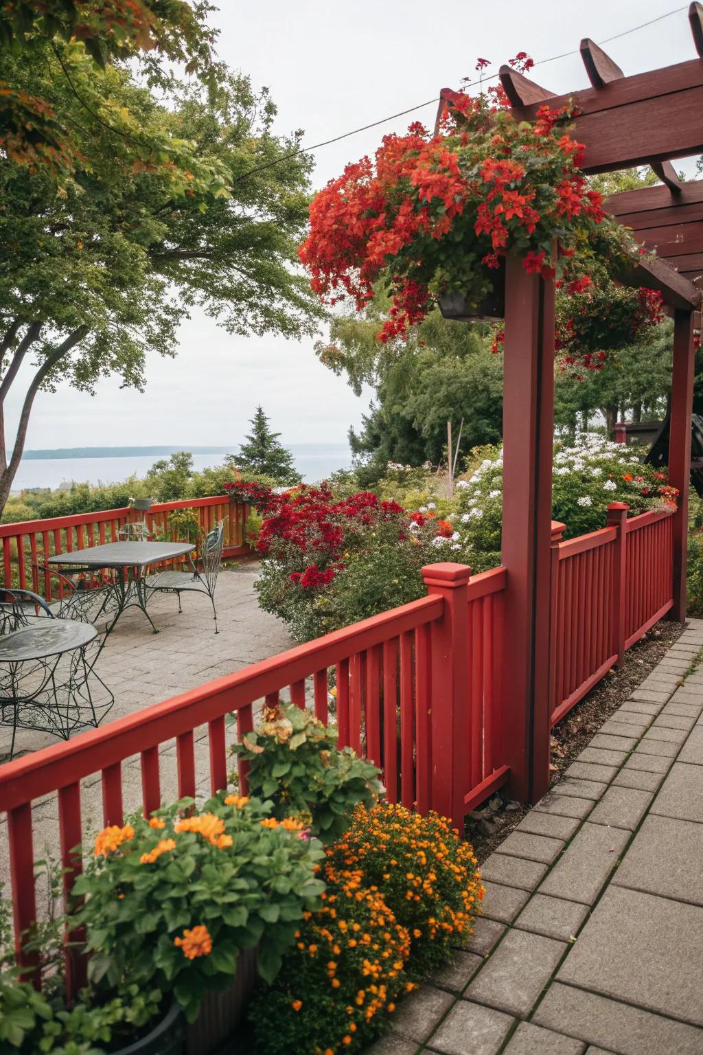 A red fence provides a vibrant backdrop for patio plants.