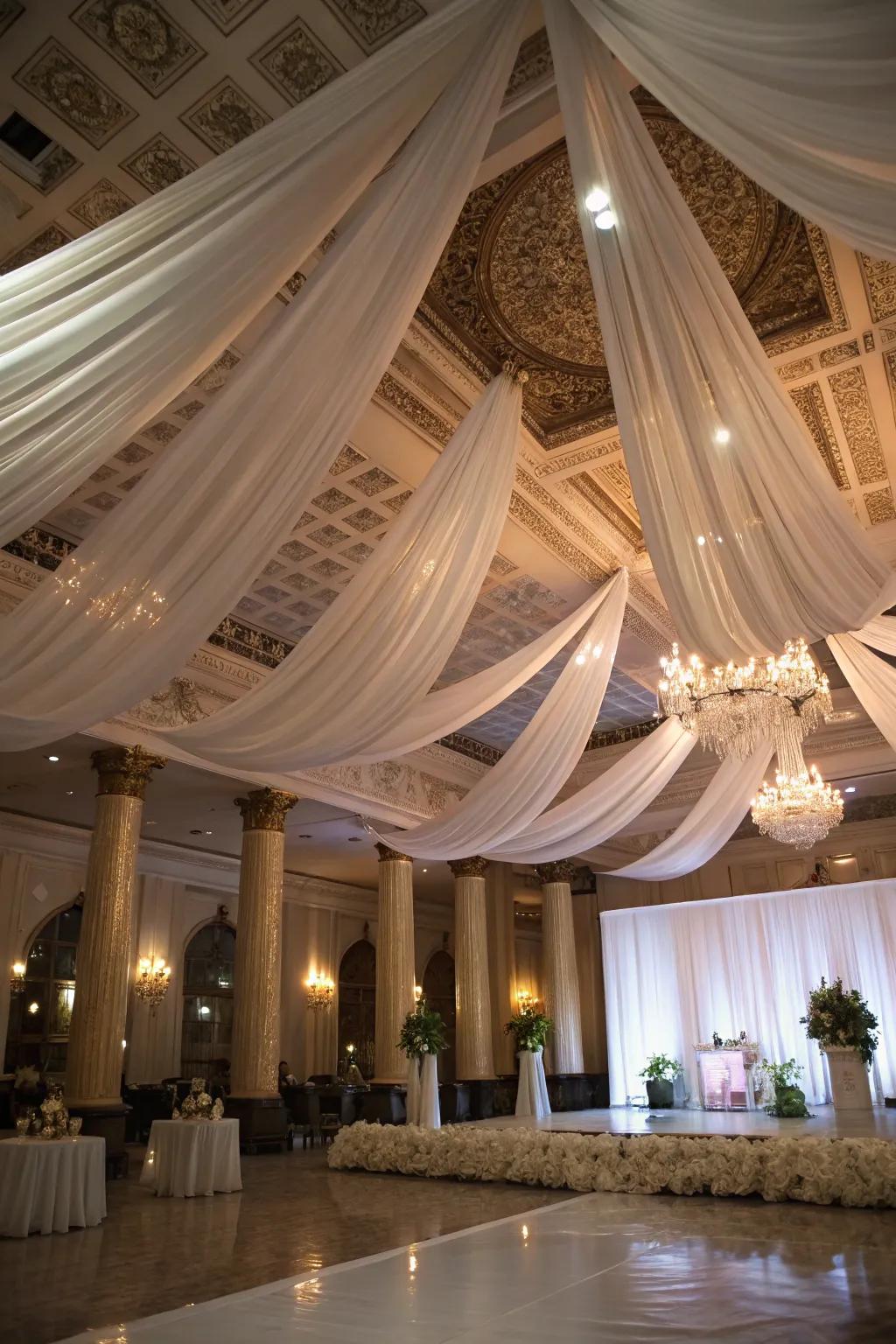 A wedding venue transformed with dramatic ceiling drapery, adding elegance.