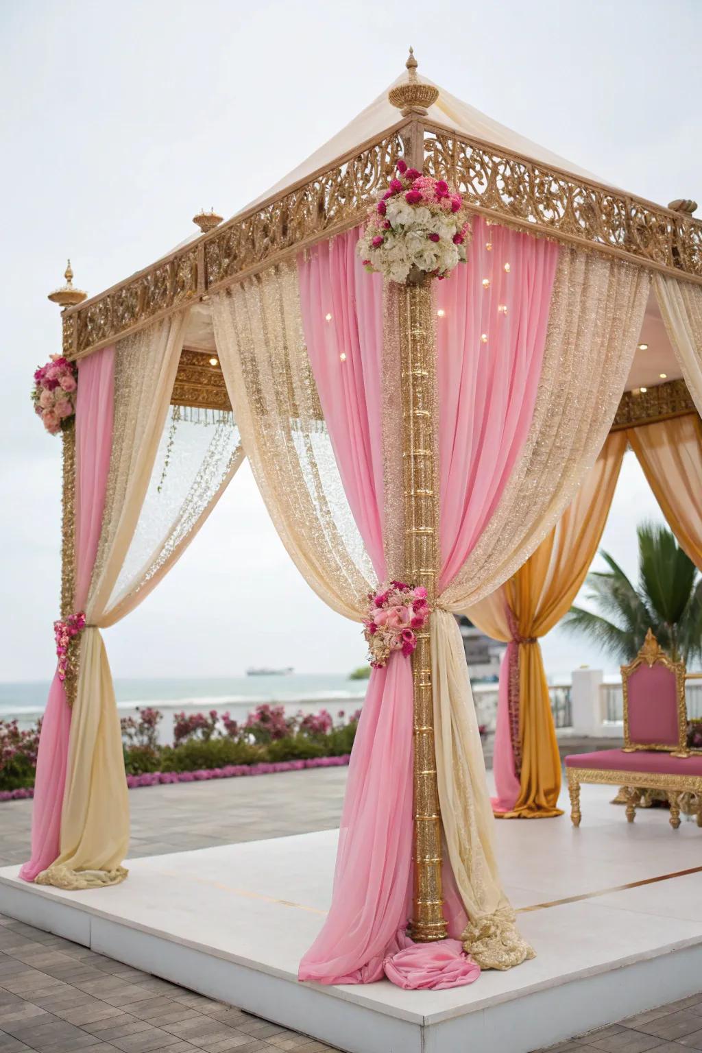 Opulent flowing cloths in gold and blush enveloping a mandap.