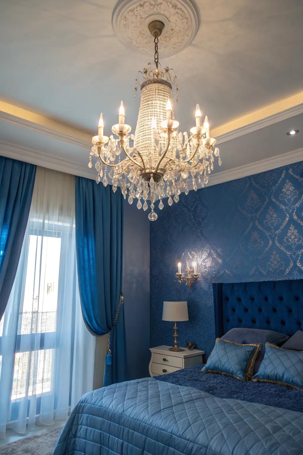 A crystal chandelier adds sophistication to a royal blue-themed bedroom.